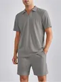 Dettaglio di un completo polo e pantaloncini grigi a pieghe da uomo. - Taglia S / Top E Pantaloni / Grigio