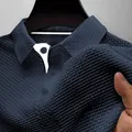 Close-up of breathable ice silk textured fabric on navy blue men's polo shirt. - Aqua