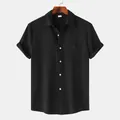 Detalle de camisa negra de manga corta con textura arrugada y un bolsillo en el pecho - Negro