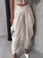 Detail shot of elegant off-white pleated high-waisted balloon trousers for women. - Light Khaki