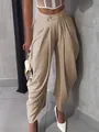 Detailed view of beige high-waisted pleated baggy trousers with a chic urban vibe - Camel