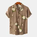 Detail of men's short-sleeved brown shirt featuring elegant white floral print patterns - S / Tops / Brown Magnolia Print
