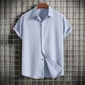 Detail view of men's light blue short sleeve shirt with textured fabric and button collar - Light Blue