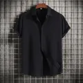 Black short-sleeved button-up shirt for men with textured fabric hanging on hanger - Black