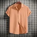 Detailed view of peach short-sleeved men's shirt with textured fabric and buttons - Orange