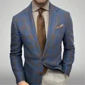 Gros plan d'un blazer pour homme à carreaux bleus et marrons avec un design rétro. - Bleu