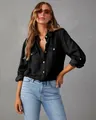 Professional detail shot of a women's black long-sleeved denim shirt with pocket details. - S / Tops / Black