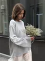 Détail d'un pull en maille grise à coupe ample présenté dans un plan lifestyle - S / Hauts / Gris