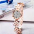 Close-up view of elegant rose gold floral bracelet watch featuring white enamel petals - Rose Gold