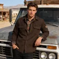 Men's vintage brown utility jacket styled with a plaid shirt outdoors. - M / Tops / Coffee