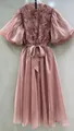 Vista de detalle de vestido rosa empolvado con mangas abullonadas y corpiño de textura. - Rosa