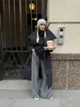 Stylish long black puffer coat worn by a model in an urban outdoor setting. - S / Tops / Black