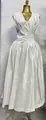 Elegante witte mouwloze maxi-jurk met plooien, een slanke taille en luxe satijnen afwerking - Wit