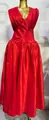 Gedetailleerd zicht op een elegante rode maxi-jurk met geplooide ruches en een V-hals. - Rood