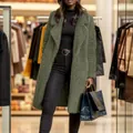 Fashionable woman wearing olive green long teddy coat with lapel collar in a boutique. - Army Green