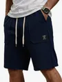 Detailansicht der dunkelblauen Waffelstrick-Shorts mit Taschenlabel und Stofftextur - S / Unterteile / Marineblau