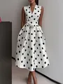 Vue détaillée d'une robe vintage sans manches à pois blancs avec col en V et ceinture nouée. - S / Hauts / Blanc