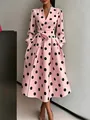 Detail view of a pink retro Audrey Hepburn style dress with bold black polka dots. - Pink