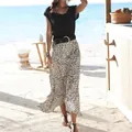 Close-up of a stylish woman wearing a patterned maxi skirt in a sunny beach resort - S / Bottoms / White