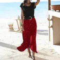 Detail view of a red polka dot fishtail midi skirt worn by a model on a sunny beach. - S / Bottoms / Burgundy