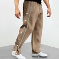Dettaglio di pantaloni marroni da uomo con bottoni a pressione laterali e strisce decorative. - Taglia S / Pantaloni e gonne / Caffè