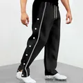 Dettaglio dei pantaloni sportivi neri con bottoni a pressione laterali e striscia grigia. - Taglia S / Pantaloni e gonne / Nero