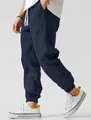 Detail view of men's navy linen joggers with white drawstring and elastic cuffs. - Navy Blue