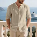 Detail shot of a men's linen Henley shirt with a stand collar in a casual beach setting. - S / Tops / Khaki