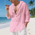 Detailed view of men's pink loose linen hooded shirt worn by a model on a sunny beach - S / Tops / Pink