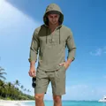 Linnen herenset met hoodie en korte broek, gepresenteerd op een tropisch strand. - Legergroen