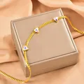 Nahaufnahme einer luxuriösen goldenen Schlangenkette mit schillernden Herzanhängern - Herz / Gold