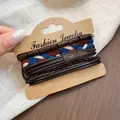 Vintage ethnic style bracelet set with wooden beads and woven cords on display card - Four-Piece Set / Brown