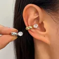 Elegant gold and silver zircon ear cuffs shown on ear and held between fingers - 2 Pieces (1 Gold + 1 Silver) / Multicolor