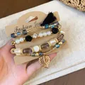 Vintage beaded bracelet set with faux pearls and gold leaf charm displayed on card - Tassel / Four-Piece Set / Gold-Black