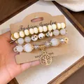 Vintage bohemian beaded bracelet set featuring cream beads and golden tree of life charm - Tree of Life / Three-Piece Set / White