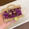 Multilayered purple beaded bracelet set featuring a gold-tone engraved heart charm - Heart / Four-Piece Set / Gold-Purple