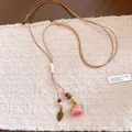 Detailed view of preserved rose flower necklace with wood beads and leaf pendant - Pink