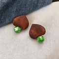 Close-up detail of ethnic style wooden heart-shaped earrings with green marbled glass beads - Heart Wood Green Bead Style (HE35378) / Brown-Green / Silver