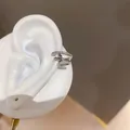 Primer plano detallado del manguito de oreja plateado con circonitas y estrella - Brazalete de Oreja de Hoja / Plateado