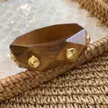 Close-up of geometric wooden bangle with gold rivets and natural wood grain texture - Geometric Faceted Rivet Style (8#) / Brown