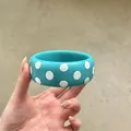 Chic teal resin bangle featuring white polka dots held by hand for a vacation look - Round Bracelet / Blue-White Polka Dot