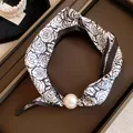 Detail van zwart-witte rozen zijden sjaal ketting met een grote parel magnetische hanger - Bruin Bloemenpatroon Stijl / Koffie