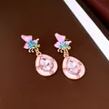 Detalle de pendientes de mariposa de esmalte con cristales rosas y claros brillantes - Pendientes de botón / Oro-Rosa
