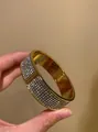 Detailed view of a vintage gold-tone wide bangle encrusted with shimmering rhinestones - Pave Rhinestone Metal Style (HB6800-3) / Gold