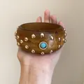 Detailansicht eines hölzernen Armreifs mit Goldnieten und Türkis-Inlay im Retrostil - Vintage Holzmaserung Türkis Breit / Dunkelbraun-Goldene Nieten