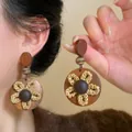 Detailweergave van vintage bruine houten oorbellen met een handgebreid bloemontwerp - Stijl 1 (HE35489-1) / Bruin