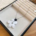 Detail view of a minimalist white resin flower pendant on a dainty silver chain - White Marble Floral Style (71#) / Silver / White