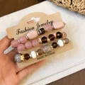 Boheemse kralenarmbandenset met strassteentjes en glaskralen op displaykaart. - 4-delige set / Goud-Koffie