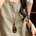 Close-up of retro brown wooden oval ring pendant necklace on model with linen dress - Nested Ring Style (74#) / Coffee
