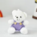 Primo piano dettagliato di un orsetto di peluche bianco con salopette in velluto a coste viola. - Orsetto Bianco con Salopette Viola
